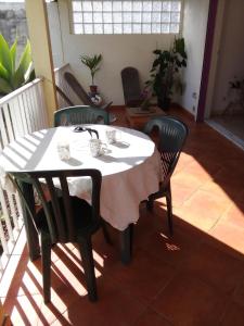 a dining room table with two chairs and a white tablecloth at Entre mer et montagne in Le Tampon