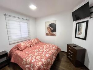 a bedroom with a bed and a dresser and a window at Hospedaje Nuevo Amanecer in Antofagasta