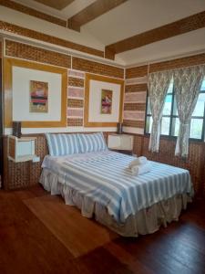 una camera da letto con un grande letto con due asciugamani di Greenviews Resort & Restaurant Port Barton a San Vicente
