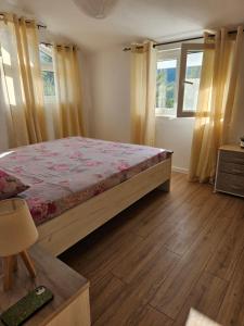 Schlafzimmer mit einem Bett und Holzboden in der Unterkunft Sunny Valley in Bar