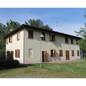 a large white house with boarded up windows at La Rizza in Bentivoglio