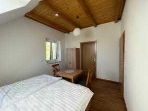 a bedroom with a bed and a wooden table at Ferienhaus am Hof Zotter in Riegersburg