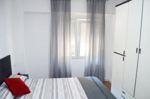 Un dormitorio con una cama con una almohada roja encima. en Casa Bia Plus, en Elche