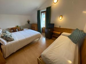 a hotel room with two beds and a television at Hotel Col Serena in Etroubles