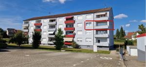 an apartment building with red balconies and a parking lot at TOP 3-Zimmerwohnung nähe Kurpark in Bad Rappenau