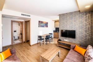 ein Wohnzimmer mit einem Sofa und einem TV in der Unterkunft Golden World Suite Hotel in Antalya
