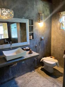 uma casa de banho com um lavatório e um WC em Pousada Casa da Praia em Caraíva