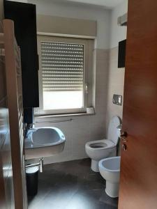 a bathroom with a toilet and a sink and a window at Casa MaryGiò in San Giovanni Teatino