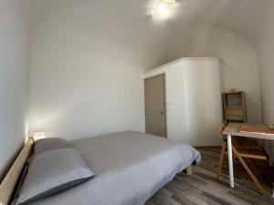 Habitación pequeña con cama y escritorio. en Al Belvedere Affittacamere, en Cuneo