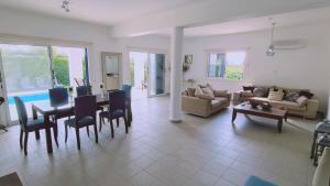 a living room with a table and chairs and a couch at STAY Calypso Villa in Peyia