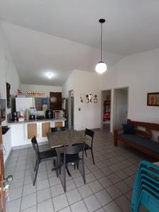 a kitchen and living room with a table and chairs at Onda Colorida - Praia de Serrambi (CASA 1 - ROSA) in Porto De Galinhas