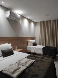 a hotel room with two beds and a air conditioner at Pousada Velho Chico in Vargem Bonita