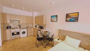 a kitchen with a bed and a table in a room at STAY Napa Velvet Apartment in Ayia Napa