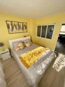 1 dormitorio con 1 cama grande y pared amarilla en Appartement vue Saint Joseph en Le Havre