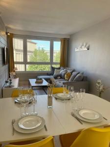 a dining room table with chairs and a living room at Appartement vue Saint Joseph in Le Havre