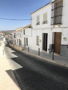 una calle con edificios blancos en una calle adoquinada en A hidden gem in Estepa. With Dip pool, WiFi, BBQ!, en Estepa