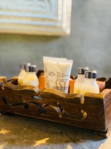 a wooden tray with two bottles of soap and a container of milk at Pousada Casa da Praia in Caraíva