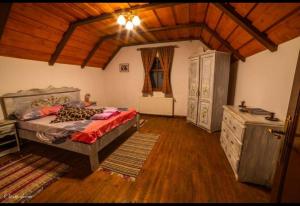 1 dormitorio con 1 cama y suelo de madera en Casa de hodina Maria en Sîngeorz-Băi
