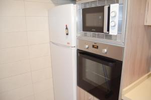una cucina con frigorifero bianco e forno a microonde di Casa Bia Plus a Elche