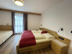 a bedroom with two beds and a large window at Da Kathi in San Candido