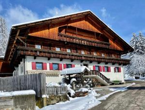 ein großes Holzgebäude mit Schnee darauf in der Unterkunft Da Kathi in Innichen