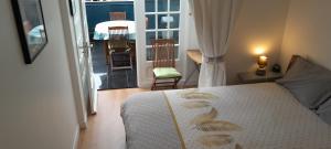 1 dormitorio con cama y vistas a un balcón en Ecrin de tranquillité - Centre Village en Barneville-Carteret
