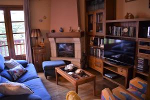a living room with a blue couch and a tv at Casa Rural Galain in Lizaso