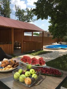 stół z kilkoma talerzami owoców w obiekcie Hasy tun Guest House in GARNI 2 w Garni