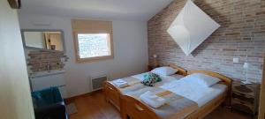 um quarto com uma cama e uma parede de tijolos em La Reine-des-prés em Vernamiège