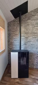 a black and white stove in a room with a brick wall at La Reine-des-prés in Vernamiège