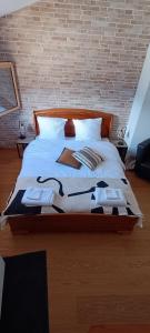 1 cama grande con sábanas blancas y almohadas. en La Reine-des-prés, en Vernamiège