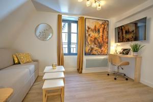 a living room with a couch and a desk and a window at Le GoldenLeaf - Netflix/Wi-Fi Fibre - Séjour Lozère in Mende
