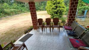 a group of chairs sitting on a porch at Blue Petal Homestay in Virajpet