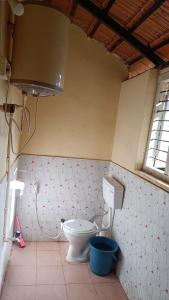 a bathroom with a toilet and a window at Blue Petal Homestay in Virajpet