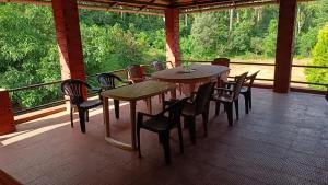 a patio with tables and chairs on a porch at Blue Petal Homestay in Virajpet