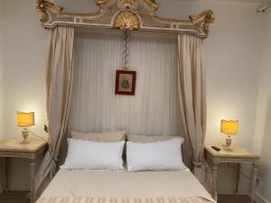 a bedroom with a canopy bed with two lamps at Piccolo Borgo Antico in Brescia
