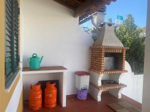 d'une terrasse avec un four à pizza sur le côté d'une maison. dans l'établissement Casa do Almograve, à Odemira