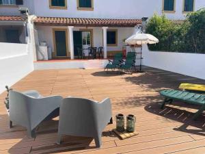 eine Terrasse mit einem Tisch, Stühlen und einem Sonnenschirm in der Unterkunft Casa do Almograve in Odemira