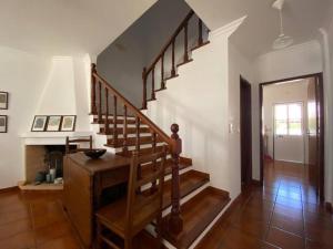 uma escada de madeira numa sala de estar com um corredor em Casa do Almograve em Odemira