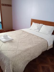 een bed met een wit dekbed en een dienblad bij Hospedaje Feliz in Chimbote