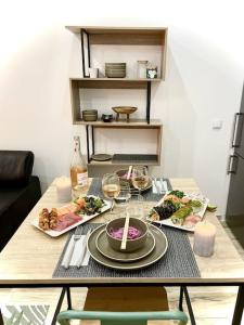a table with plates of food and glasses of wine at Perpignan Centre : Superbe appartement en Roof-top in Perpignan