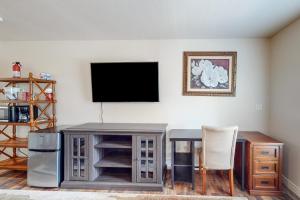 a living room with a table and a flat screen tv at Hidden Valley Haven - Unit B in Prescott