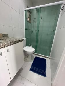 a bathroom with a toilet and a glass shower at Apt 3 Minutos Praia do Forte - Ar Condicionado in Cabo Frio