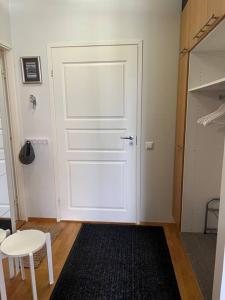 a white door in a room with a table and a stool at Saunallinen kaksio keskustassa in Kokkola