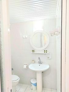 アルガッシにあるAthina apartmentsの白いバスルーム(シンク、鏡付)