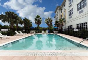 a large swimming pool in front of a building at Palm Coast Hotel & Suites-I-95 in Palm Coast