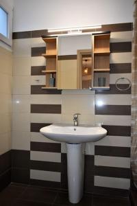 a bathroom with a white sink and a mirror at Smailis apartment 2 in Lygourio