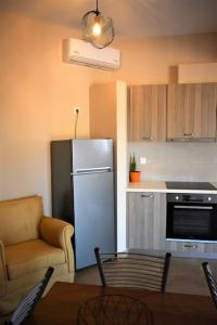 a kitchen with a refrigerator and a table and a chair at Smailis apartment 2 in Lygourio