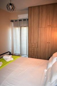 a bedroom with a large bed and a wooden cabinet at Smailis apartment 2 in Lygourio