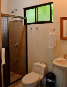 a bathroom with a shower and a toilet and a sink at Hotel D'Lucia - Quebrada Ganado, Jaco, Costa Rica in Puntarenas